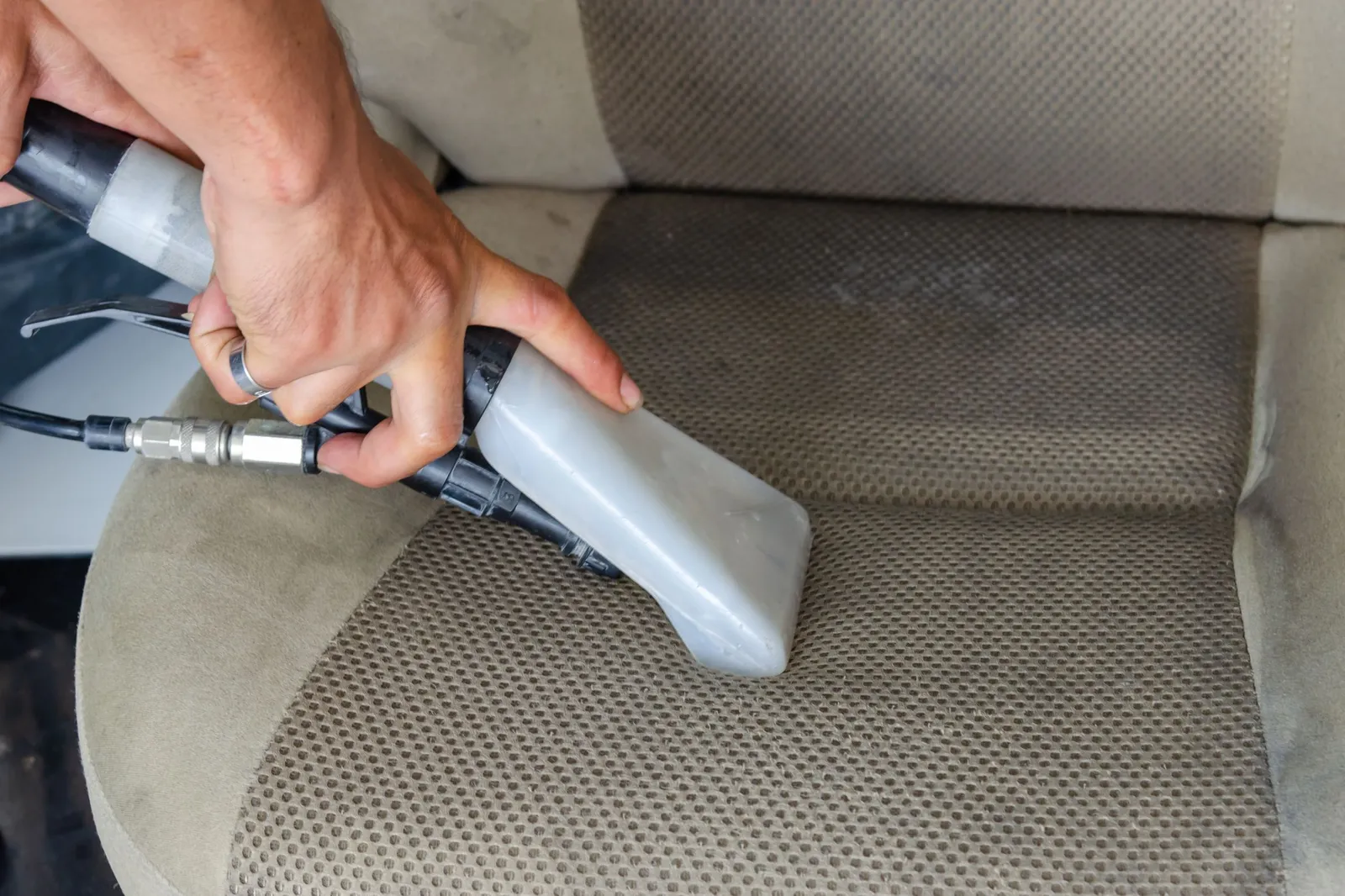 Limpeza de estofos com máquina de extração no interior de um carro no Seixal